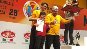 podio di mario matarazzo con riflessi d'oro medaglia argento con la pizza mondiali stg